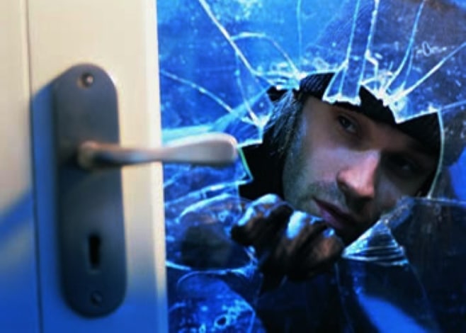 Burglar breaking glass